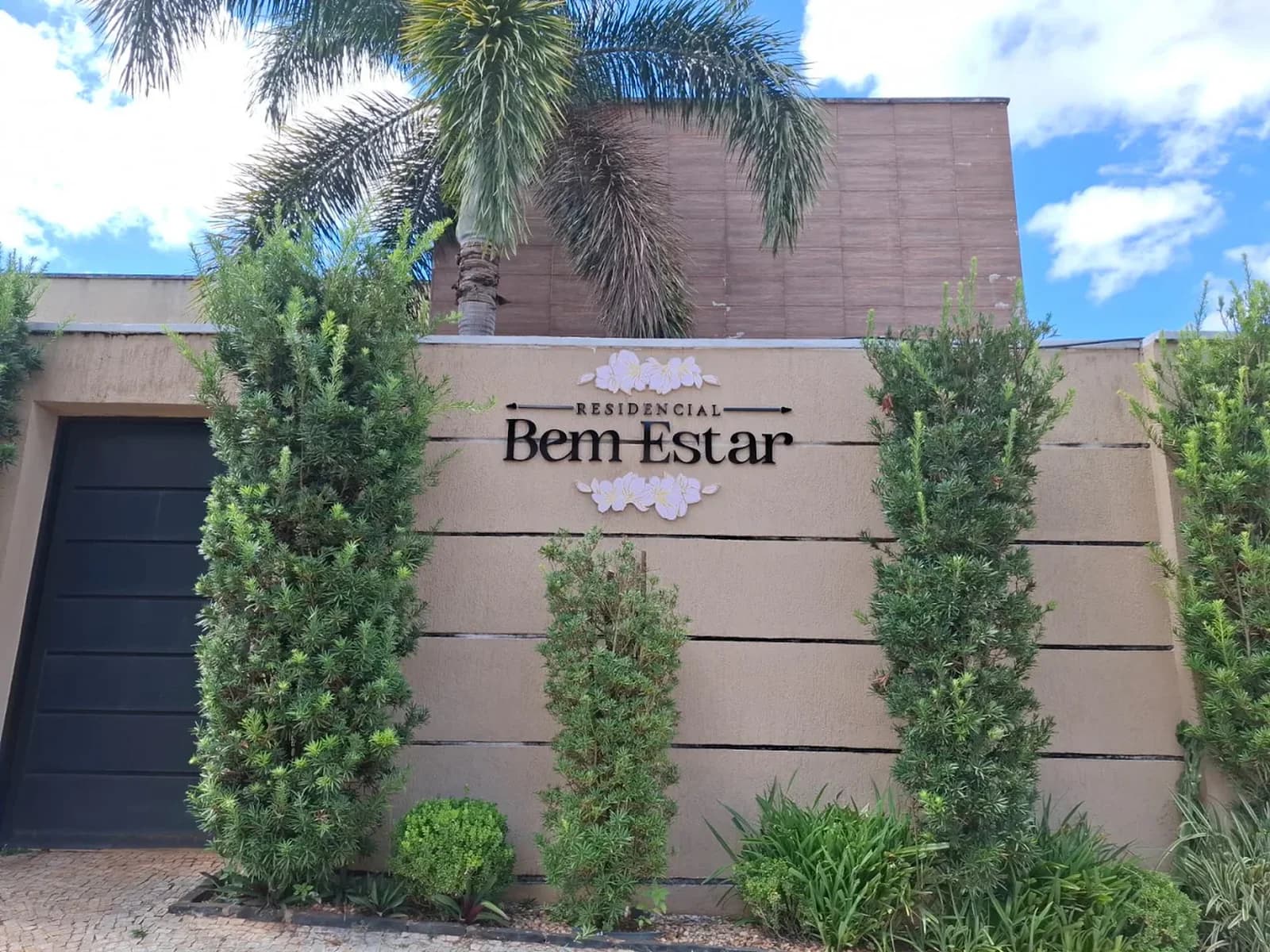 Fachada do Residencial Bem Estar com jardim e identificação da casa