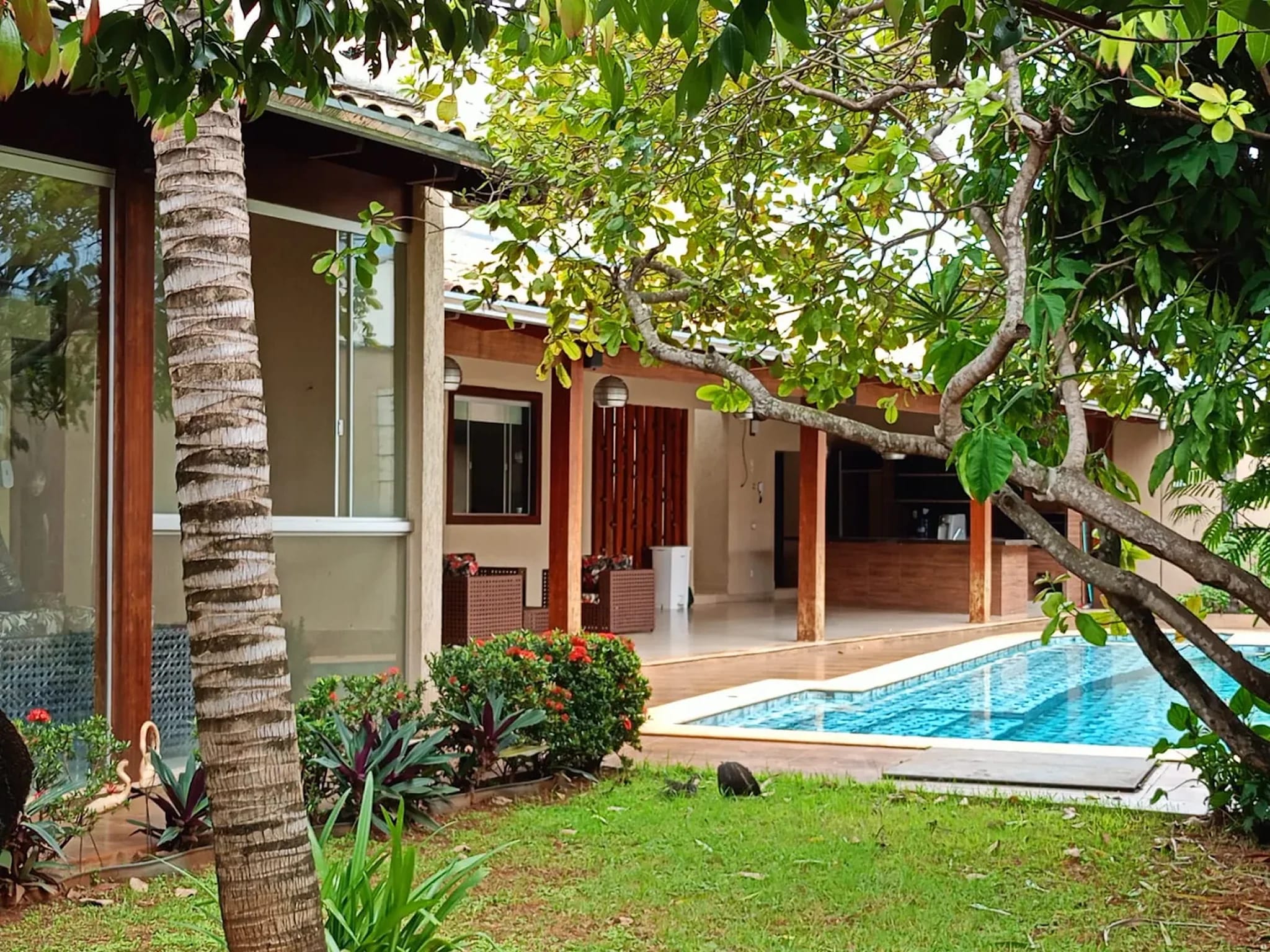 Jardim arborizado com piscina e área externa do Residencial Bem Estar